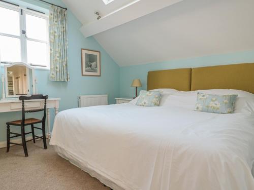 a bedroom with a large white bed and a desk at The Hayloft in Bromyard