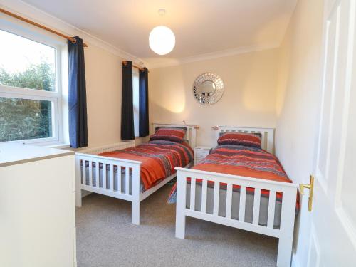 two twin beds in a room with a window at The Waiting Room in Norwich