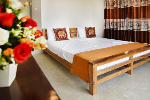 a bedroom with a bed and flowers in a room at Lodge in 611 in Kandy