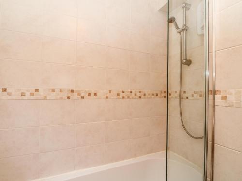 a bathroom with a shower and a bath tub at Glenfinglas Dam Cottage in Callander