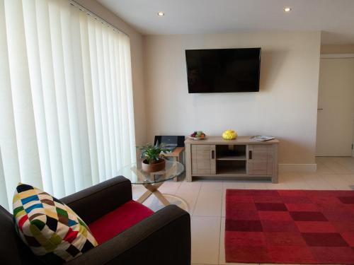 Una sala de estar con una mesa de cristal y un televisor. en Panoramic View, en Portland