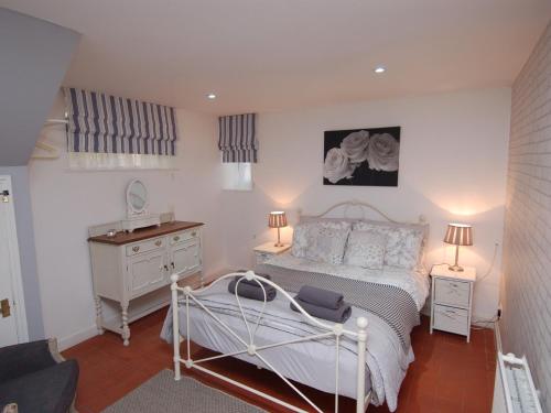 um quarto com uma cama, uma cómoda e 2 candeeiros em Hidden Treasure em Brixham