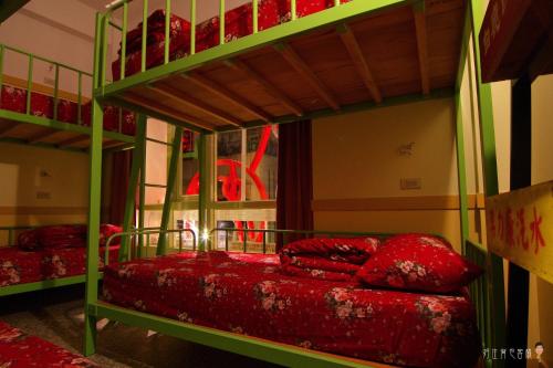 北港鎮的住宿－北港好住背包客棧，一间卧室配有两张双层床和红色枕头