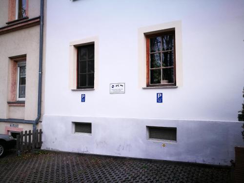 a white building with windows on the side of it at Pension & Gasthaus Nostalgie in Chemnitz