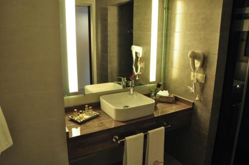 a bathroom with a sink and a mirror at Hôtel Atlas Saiss Fès in Fez