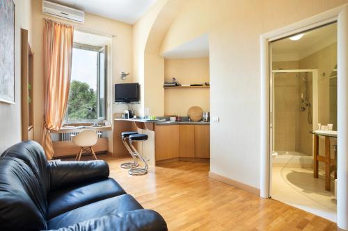 Dynasty Suites Downtown Apartments في تورينو: غرفة معيشة مع أريكة ومطبخ