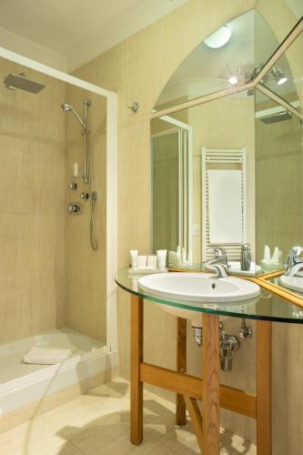 a bathroom with a sink and a shower and a tub at Dynasty Suites Downtown Apartments in Turin