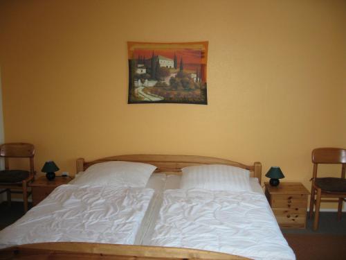 a bed in a bedroom with a painting on the wall at In der Waldemei in Medebach