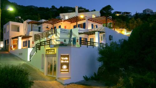 a large white building with a sign in front of it at Vasilis Studios in Myrties