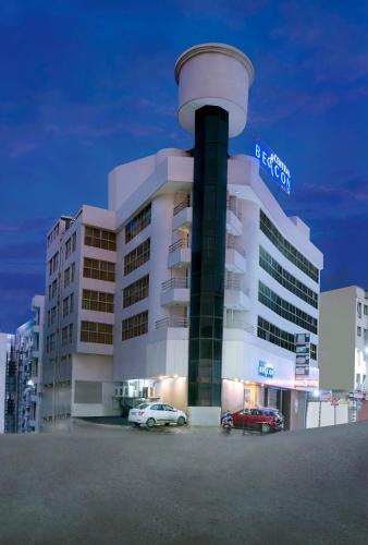 a large building with cars parked in front of it at Central Beacon Hotel in Surat