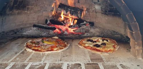 two pizzas are cooking in a brick oven at Redcliffe Hotel in Inverness