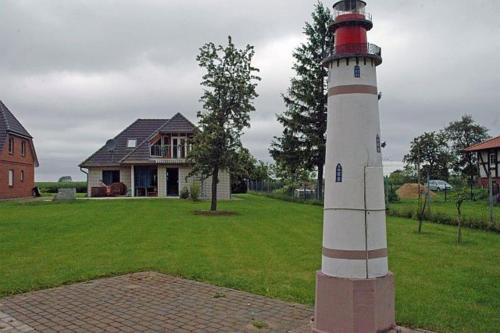 a red and white lighthouse in front of a house at Ruegen_Fewo 137 in Zudar
