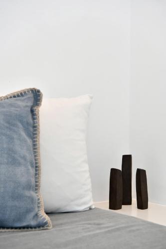 a pillow and a group of black objects on a bed at Thiro Santorini in Fira