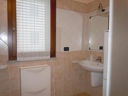a bathroom with a sink and a toilet and a mirror at Abitare in Vacanza in La Caletta