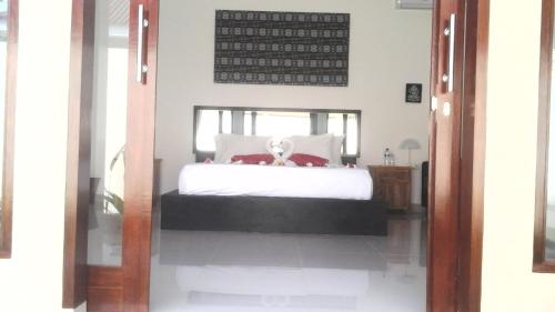 a bedroom with a bed with white sheets at villa tom and jerry in Senggigi 