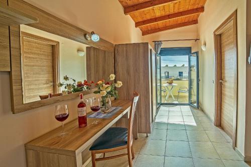 a kitchen with a counter with a glass of wine at Blue Aegean Hotel & Suites in Gouves