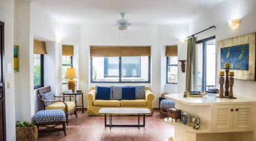 a living room with a yellow couch and chairs at Royal Palms 6 condo in Playa del Carmen