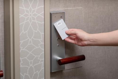 a person holding a piece of paper in a door at Shinjuku Washington Hotel Annex in Tokyo