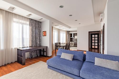 a living room with a blue couch and a table at Zhilyanskaya 30а apartments in Kyiv
