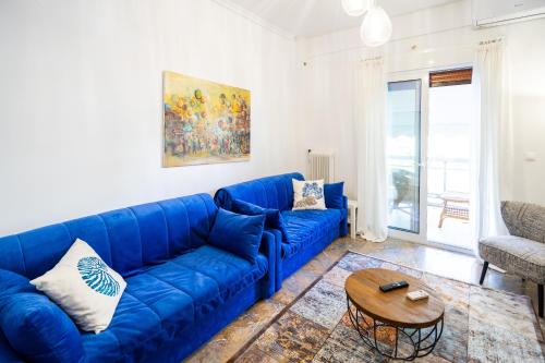 - un canapé bleu dans le salon avec une table dans l'établissement Unique apartment in Glyfada center, à Athènes