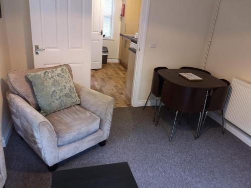 a living room with a chair and a table at Coastal Escape Deal - 2 Bedroom House at Kent Escapes Short Lets & Serviced Accommodation Kent, Wifi in Deal