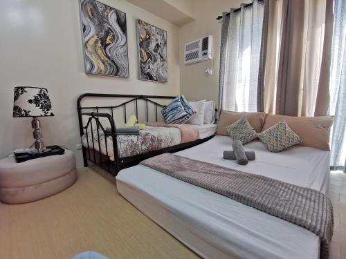 a living room with two beds and a couch at Avida Davao by davaobnb & Lemonique Homes in Davao City