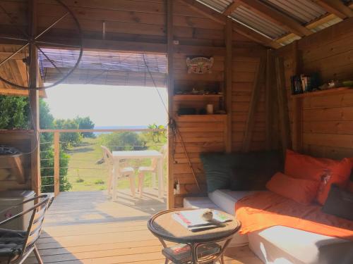 Habitación con cama y balcón con mesa. en Bungalow de charme vue mer en Beauséjour