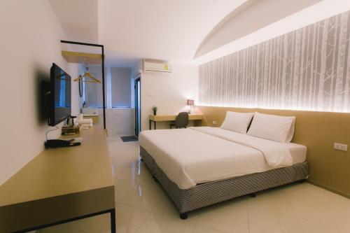 1 dormitorio con 1 cama y escritorio en una habitación en Royal Princess City Lamphun Hotel en Lamphun