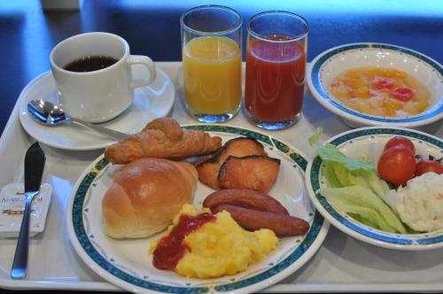 bandeja con alimentos para el desayuno y bebidas en una mesa en Smile Hotel Matsuyama en Matsuyama