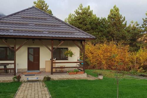 a gazebo with a bench in a yard at Limpedea Green House in Baia Mare