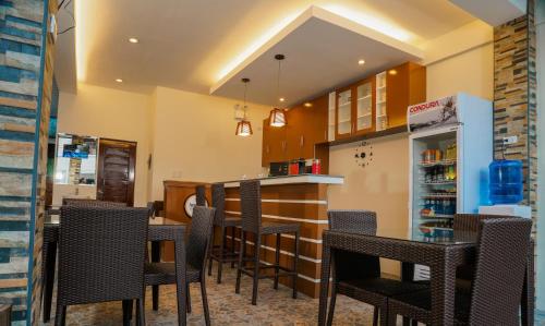 een restaurant met tafels en stoelen en een bar bij Amigos Dauin Hostel in Dauin
