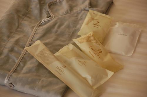 a group of white bags sitting on a bed at Hotel Trusty Tokyo Bayside in Tokyo