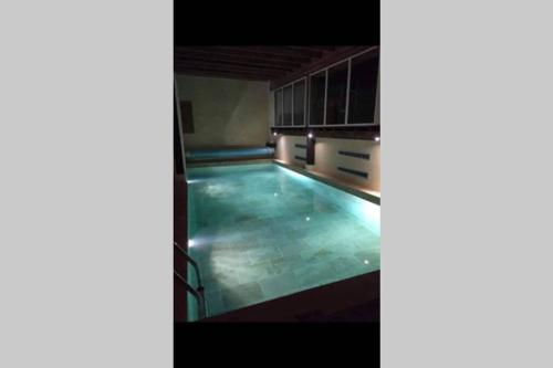 une grande piscine dans un immeuble dans l'établissement Ancienne Abbaye de Franquevaux Camargue, à Franquevaux