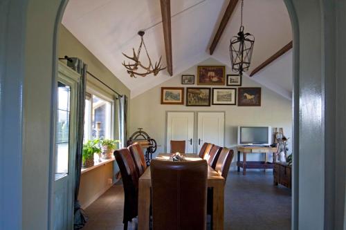 a dining room with a table and chairs and a television at Het Jachthuus - Vakantiewoning Oscar Hoeve in Ede