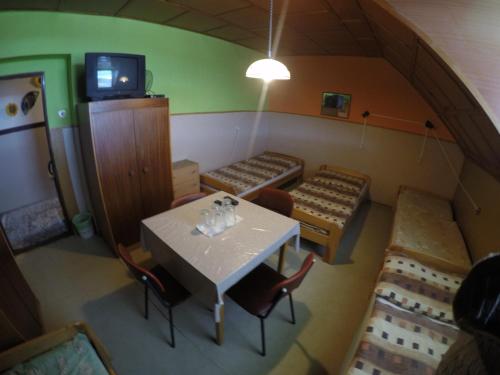 a room with a table and chairs and a tv at Turistika ubytovňa sivá brada in Spišské Podhradie