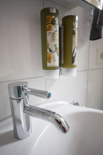 a bathroom sink with a faucet and two bottles of soap at Hotel Azenberg in Stuttgart