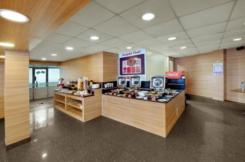 a fast food restaurant with a counter with food at Central Beacon Hotel in Surat