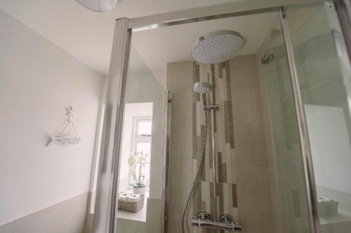 a shower with a glass door in a bathroom at Corffe House and Holiday Cottages in Barnstaple
