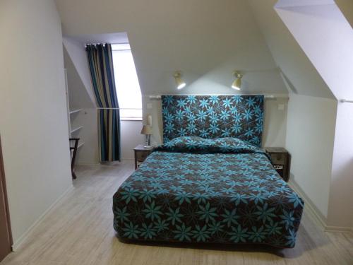 1 dormitorio con 1 cama con colcha verde en Hotel Le Progrés Dorlotel, en Le Mont-Dore