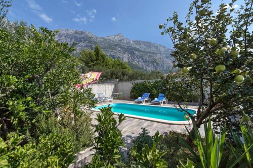 una piscina con montañas en el fondo en Apartments Vele, en Makarska