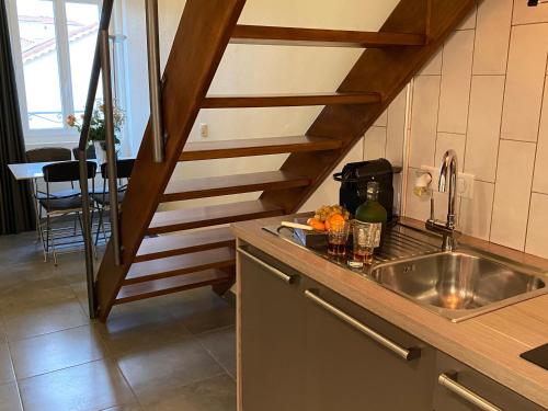 uma cozinha com um lavatório e uma escada de madeira em Cannes City Suites em Cannes