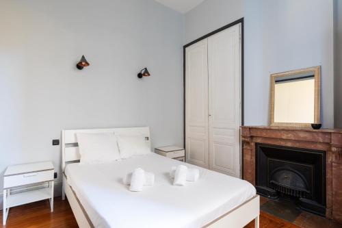 a bedroom with a white bed and a fireplace at DIFY Masséna - Brotteaux in Lyon