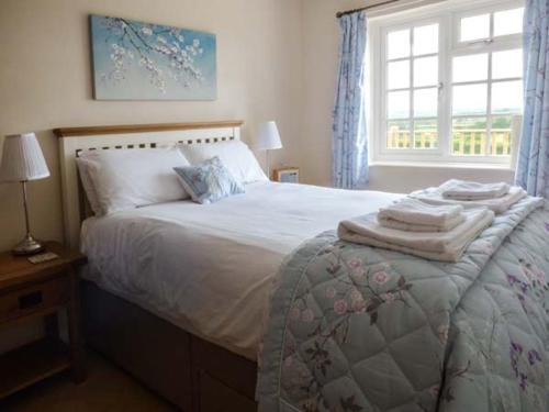 a bedroom with a bed with towels on it at Primrose Cottage in Malton