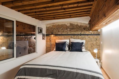 ein Schlafzimmer mit einem großen Bett in einer Ziegelwand in der Unterkunft DIFY Bear & Co - Hotel de Ville in Lyon
