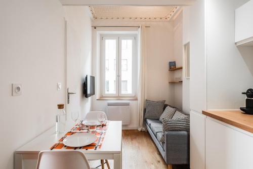 uma pequena sala de estar com uma mesa e um sofá em DIFY Suchet - Confluence / Perrache em Lyon