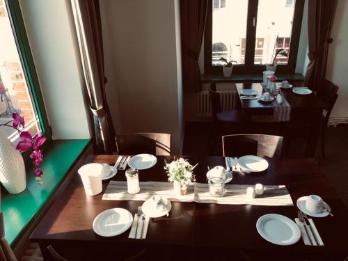 a table with plates and napkins on top at Zum Kaiserlichen Postamt in Parchim