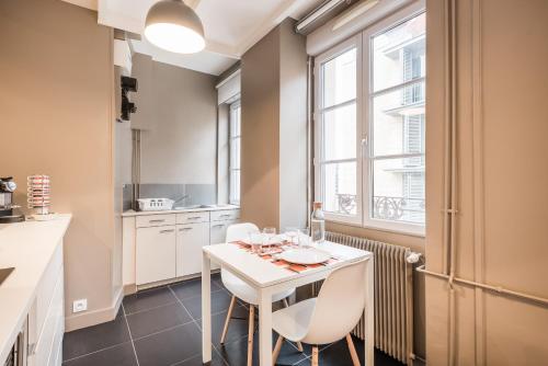 une cuisine avec une table et des chaises ainsi qu'une fenêtre dans l'établissement DIFY Seguin - Confluence / Perrache, à Lyon
