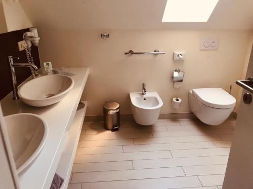 a bathroom with a sink and a toilet and a bidet at Zum Kaiserlichen Postamt in Parchim