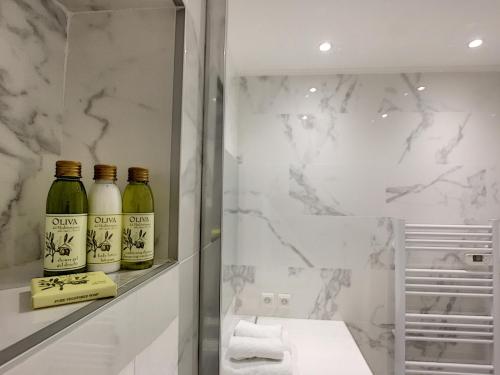 - une salle de bains avec 3 bouteilles de vin sur une étagère dans l'établissement Nestor&Jeeves - STUDIO ROYAL LUXEMBOURG - Central - Swimming pool on roof, à Nice