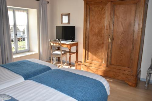 a bedroom with a bed and a desk and a television at Le Tilleul de Ray in Ray-sur-Saône